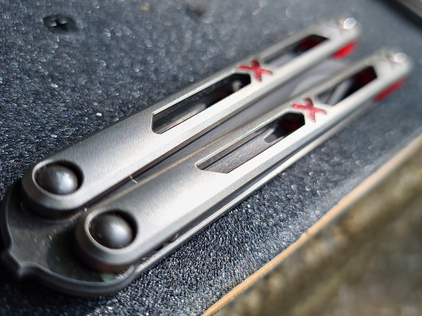 Made by Bxndxge Knives (Bandage, not bondage!) in collaboration with Zippy, the "Stitch" handles are a Titanium rehandle mod compatible with blades from both the BRS Replicant and Squid Industries Krake Raken balisongs.