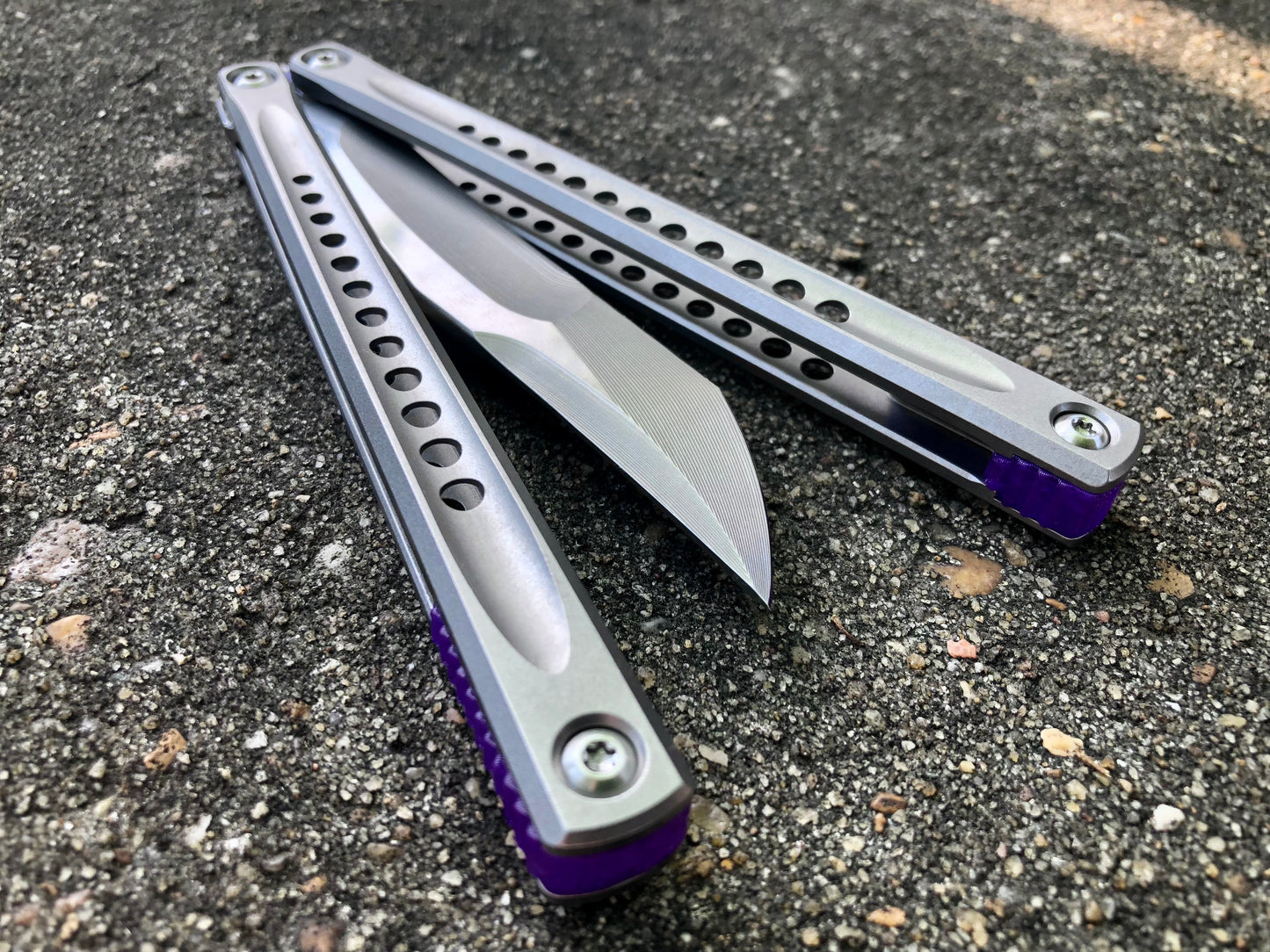 These Zippy spacers for the JK Design Embargo Balisong are made in-house from a rubbery, shatter-proof polyurethane. They add positive "saw-tooth" jimping to the Embargo and include a tungsten weight system for adjustable balance.