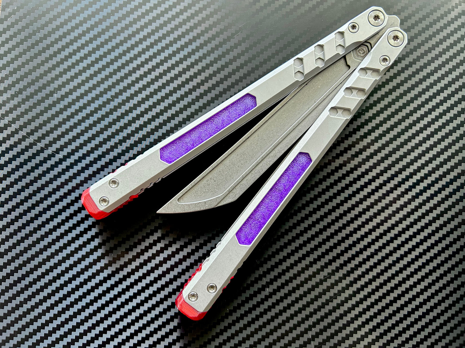 Perfect the balance and ergo of your BRS E-Volve Hex butterfly knife trainer with these custom-made Zippy spacers. The spacers are made in-house from a shatter-proof polyurethane. The spacers extend the handles, feature positive jimping, and enable adjustable balance with up to 3x removable tungsten weights per spacer.