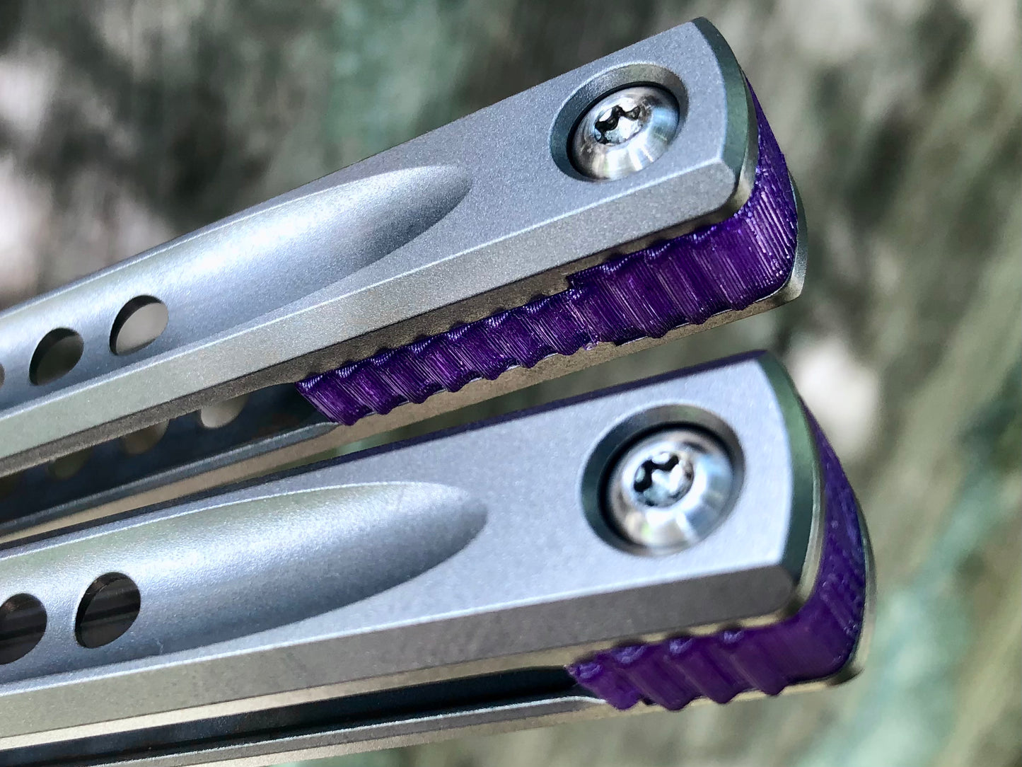 These Zippy spacers for the JK Design Embargo Balisong are made in-house from a rubbery, shatter-proof polyurethane. They add positive "saw-tooth" jimping to the Embargo and include a tungsten weight system for adjustable balance.