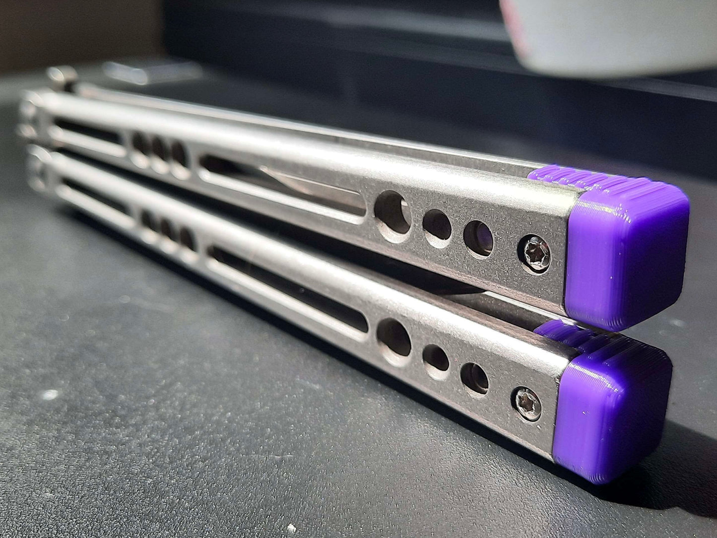 Reduce the handle bias of your HOM i-Basilisk, HOM Basilisk-R (for Titanium and G10/CF variants), and HOM Prodigy balisongs with Zippy extension spacers and handle inlays. Make your HOM Chimera balisong a more neutral flipper with Zippy spacers: full-length spacers with jimping, or spring-latch spacers that counterweight the safe handle for improved balance.