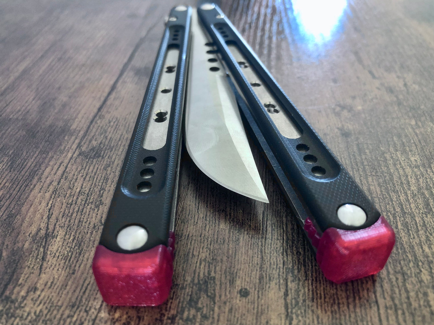 These Black Balisong Rebola v2 spacers are made in-house from a rubbery, shatter-proof polyurethane. They are ultra-lightweight extension spacers that reduce the stock handle-bias. They also feature positive sawtooth jimping and enable adjustable balance with up to 1x removable tungsten weight per spacer.