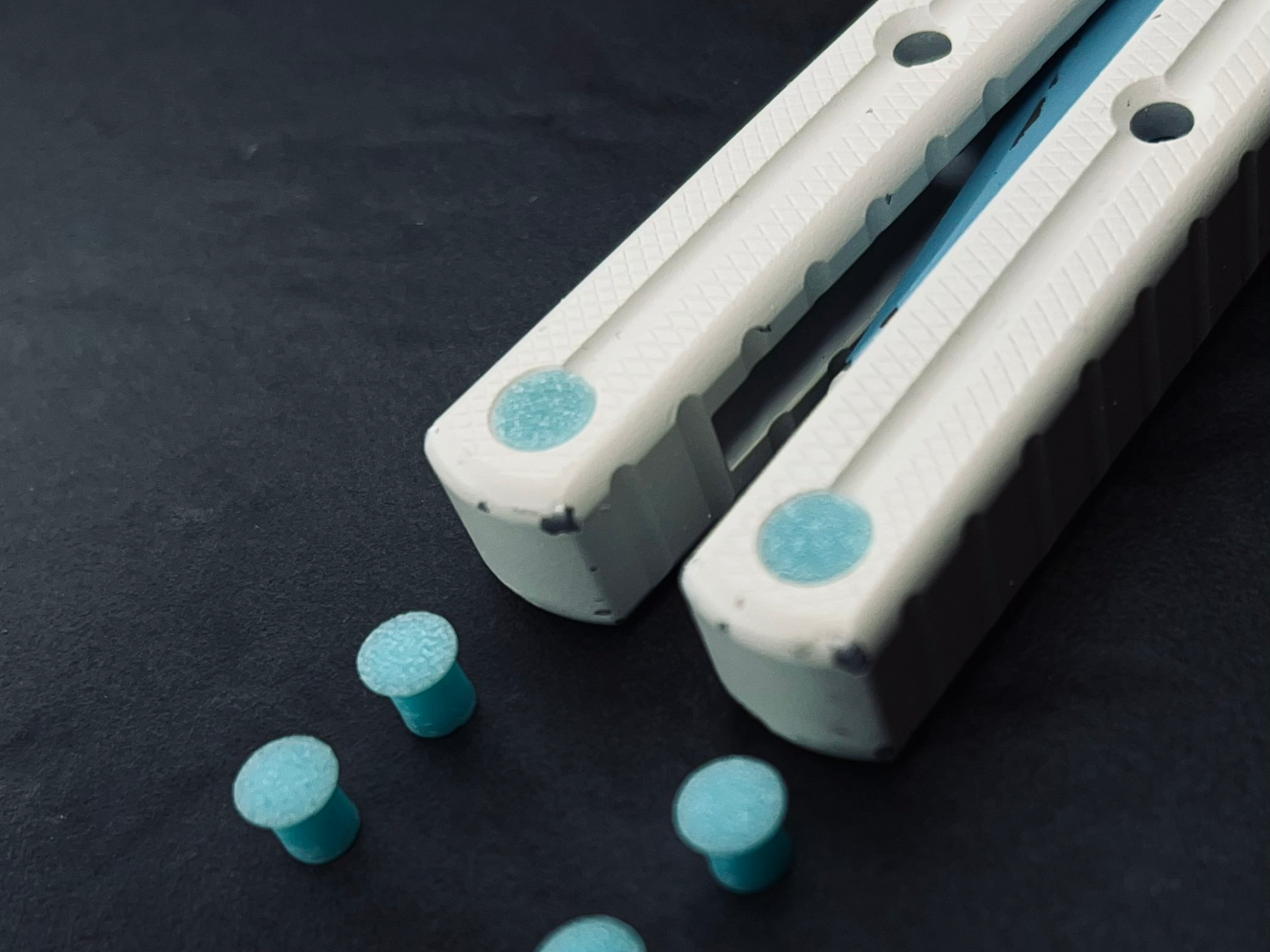 Pivot Plugs are a cosmetic handle inlay mod designed to friction fit in 3/16" bores at the bottom of a variety of balisong handles, including the Squid Industries Krake Raken balisong, the MachineWise Prysma, and the Nabalis Vulp Pro.