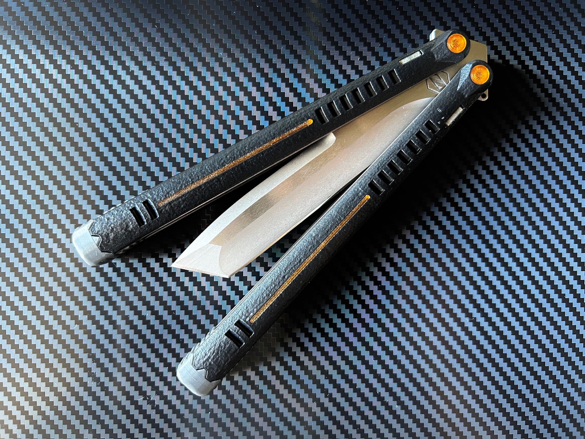 The Parallax is Zippy's first metal butterfly knife, featuring and a modular spacer system that enables rapid adjustment of handle length and balance. The innovative triple-liner design and channel scales provide enhanced rigidity compared to traditional sandwich-style balisongs. The Parallax features threadlocker-free tuning and the high-performance raceway bearing system, which is slower and more controlled compared to traditional bearings.