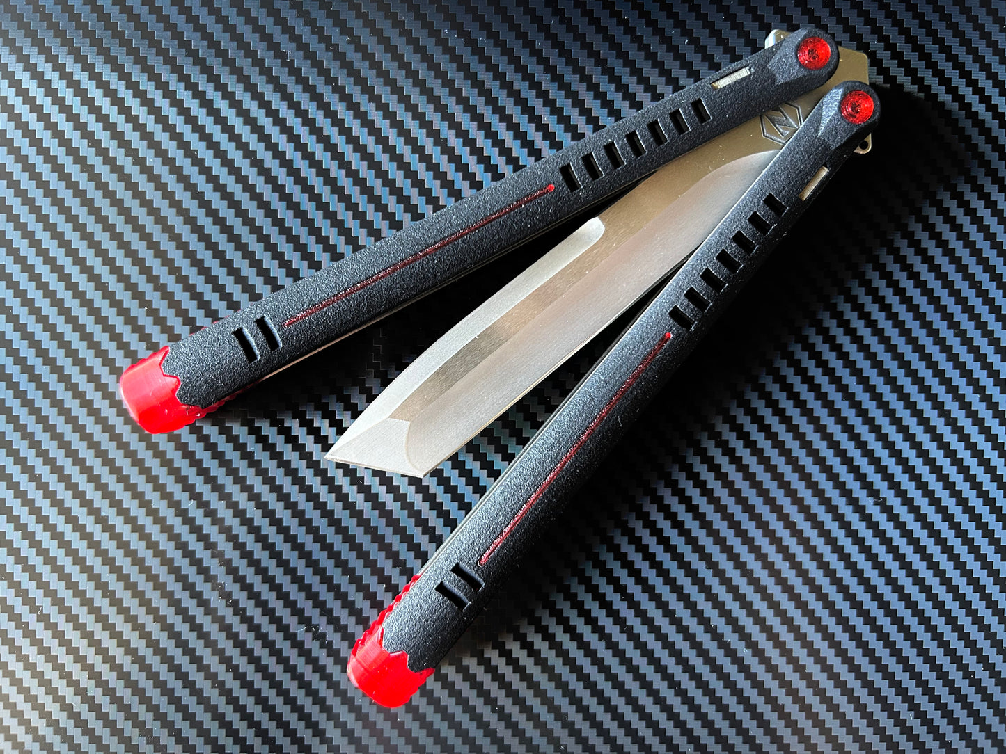 The Parallax is Zippy's first metal butterfly knife, featuring and a modular spacer system that enables rapid adjustment of handle length and balance. The innovative triple-liner design and channel scales provide enhanced rigidity compared to traditional sandwich-style balisongs. The Parallax features threadlocker-free tuning and the high-performance raceway bearing system, which is slower and more controlled compared to traditional bearings.