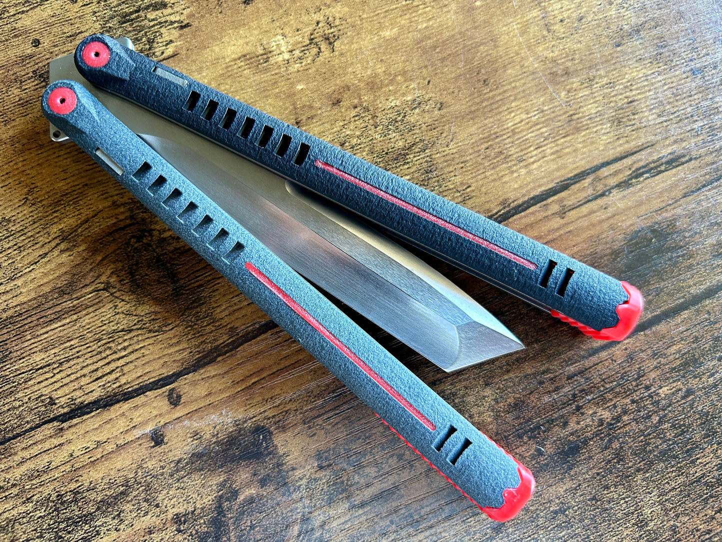 The Parallax is Zippy's first metal butterfly knife, featuring and a modular spacer system that enables rapid adjustment of handle length and balance. The innovative triple-liner design and channel scales provide enhanced rigidity compared to traditional sandwich-style balisongs. The Parallax features threadlocker-free tuning and the high-performance raceway bearing system, which is slower and more controlled compared to traditional bearings.