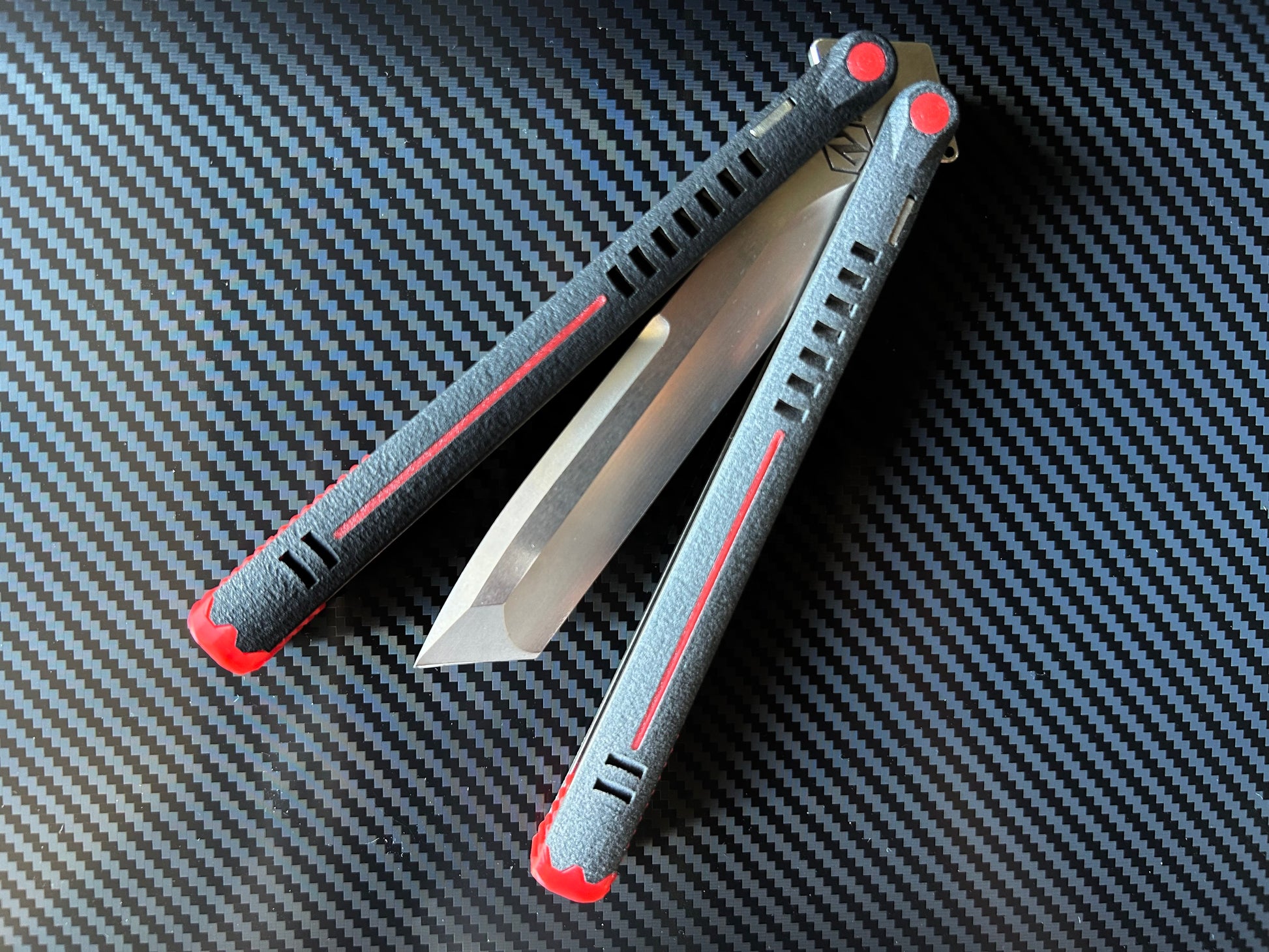 The Parallax is Zippy's first metal butterfly knife, featuring and a modular spacer system that enables rapid adjustment of handle length and balance. The innovative triple-liner design and channel scales provide enhanced rigidity compared to traditional sandwich-style balisongs. The Parallax features threadlocker-free tuning and the high-performance raceway bearing system, which is slower and more controlled compared to traditional bearings.