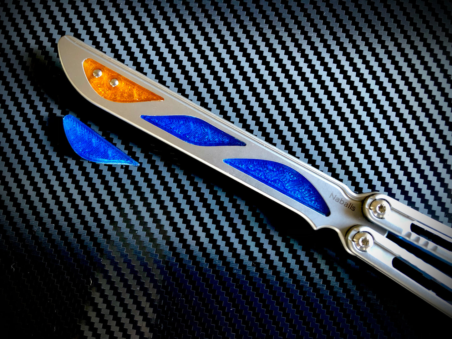 Deepen the sound, silence the ring and adjust the weight distribution of your Nabalis Canyon balisong these custom-made Zippy inlays. This mod consists of (1) speed channel inlays which silence 90% of the ring; as well as optional (2) jimping plugs which silence the ring and house a removable tungsten weight for handle-bias lovers; and (3) optional trainer blade inserts to add tip-weight and a pop of color.