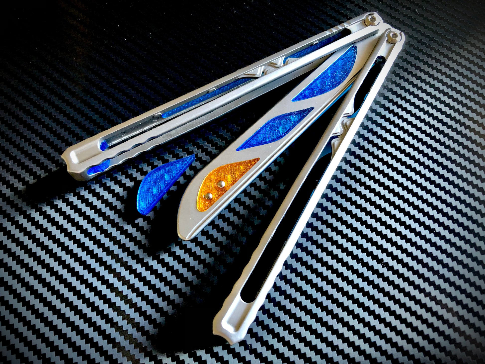 Deepen the sound, silence the ring and adjust the weight distribution of your Nabalis Canyon balisong these custom-made Zippy inlays. This mod consists of (1) speed channel inlays which silence 90% of the ring; as well as optional (2) jimping plugs which silence the ring and house a removable tungsten weight for handle-bias lovers; and (3) optional trainer blade inserts to add tip-weight and a pop of color.