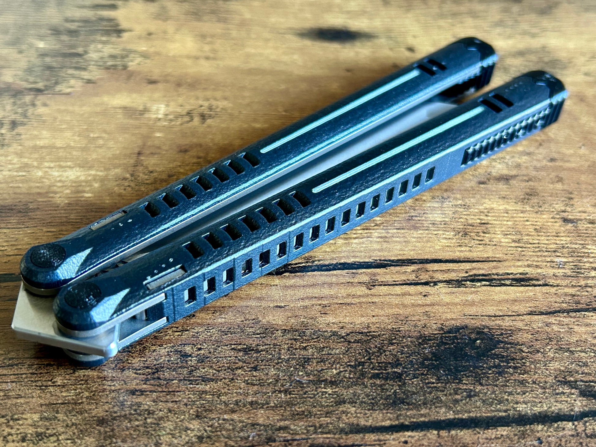 The Parallax is Zippy's first metal balisong, featuring and a modular spacer system that enables rapid adjustment of handle length and balance. The innovative triple-liner design and channel scales provide enhanced rigidity compared to traditional sandwich-style balisongs. The Parallax features threadlocker-free tuning and the high-performance raceway bearing system, which is slower and more controlled compared to traditional bearings.