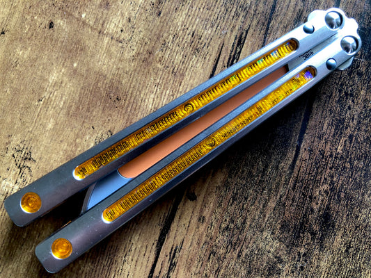 Kit out your Jimpy Designs Mashin balisong with Zippy mods: spacer weights to adjust the balance to your preference, and handle inlays to personalize the aesthetics of your Mashin. Optional pivot plugs can be used to further modify the balance or add color.